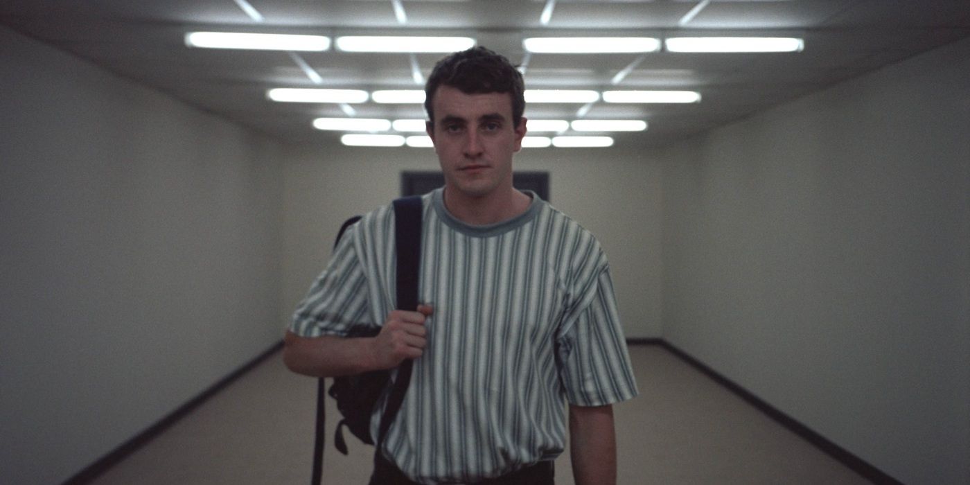 Un jeune homme marche dans un couloir blanc à Aftersun.