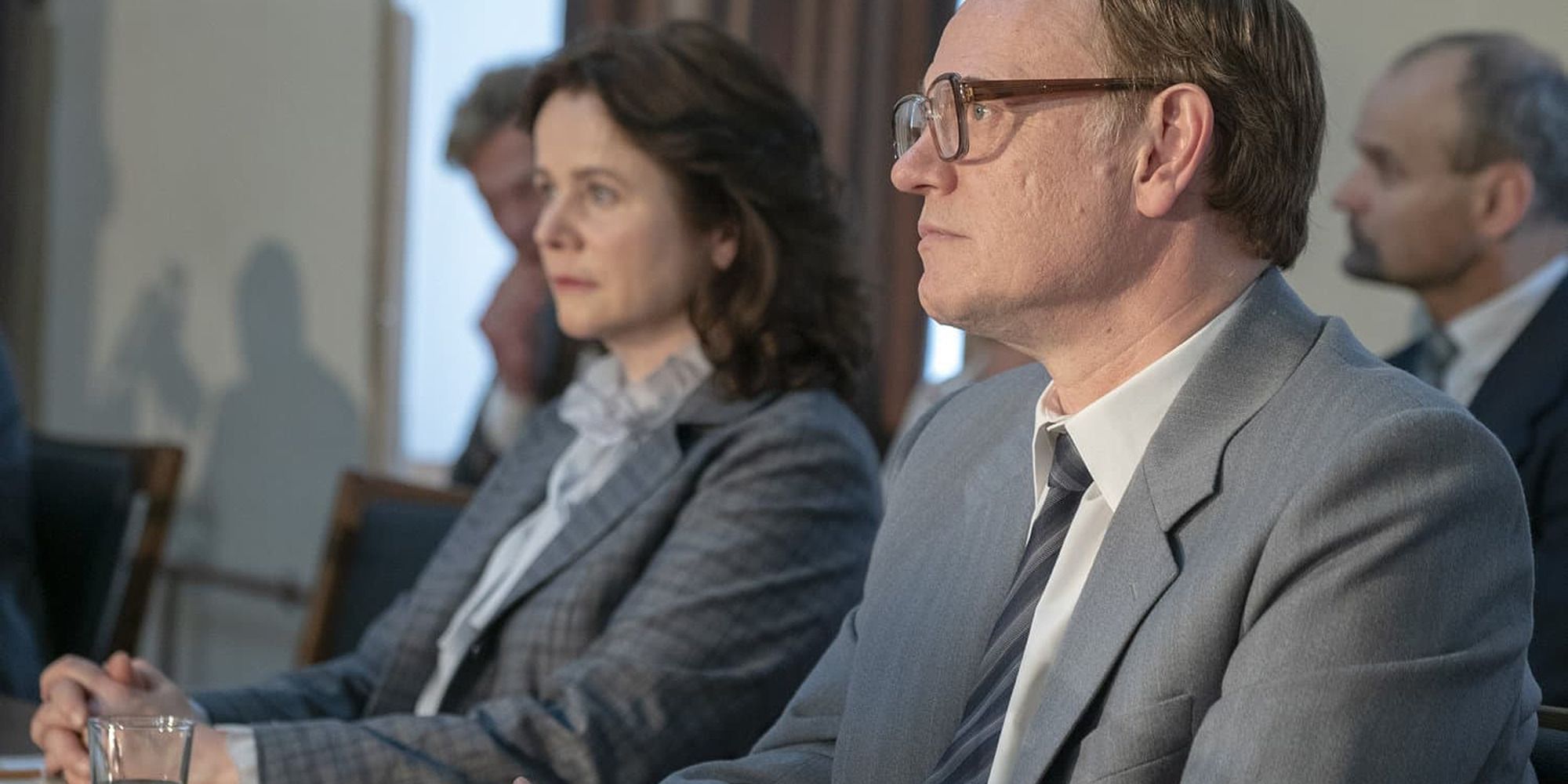 Jared Harris et Emily Watson en costume assis à une table, extrait de Tchernobyl.