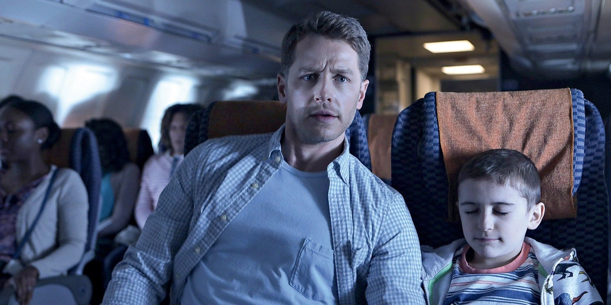 Un homme assis à côté d'un jeune garçon dans un avion dans Manifest.