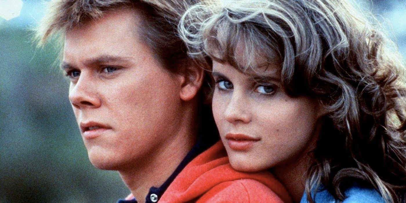 Lori Singer looks at the camera & holds Kevin Bacon from behind in Footloose
