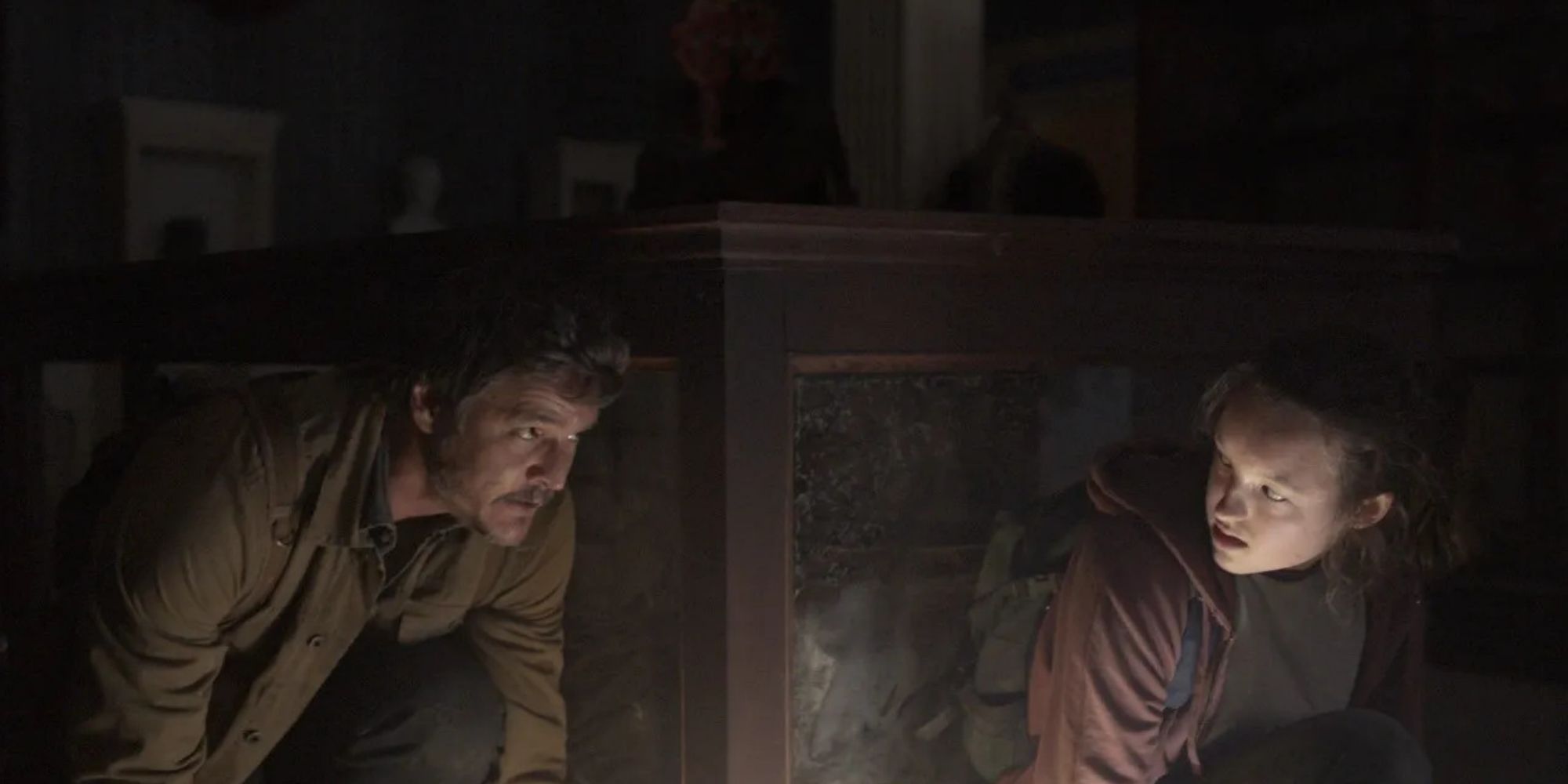 Joel (Pedro Pascal) and Ellie (Bella Ramsey) hiding from a Clicker in HBO's 'The Last of Us'
