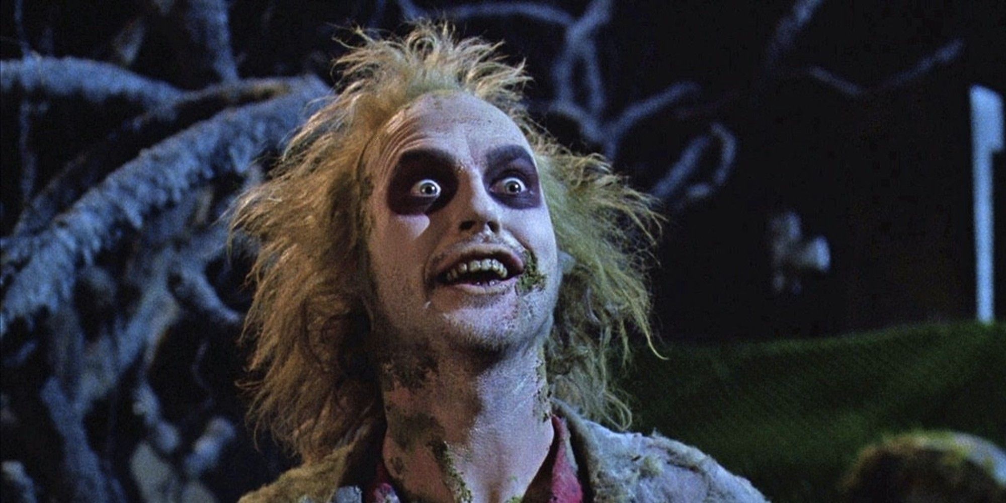 Michael Keaton as Beetlejuice with his eyes and mouth open in Beetlejuice.