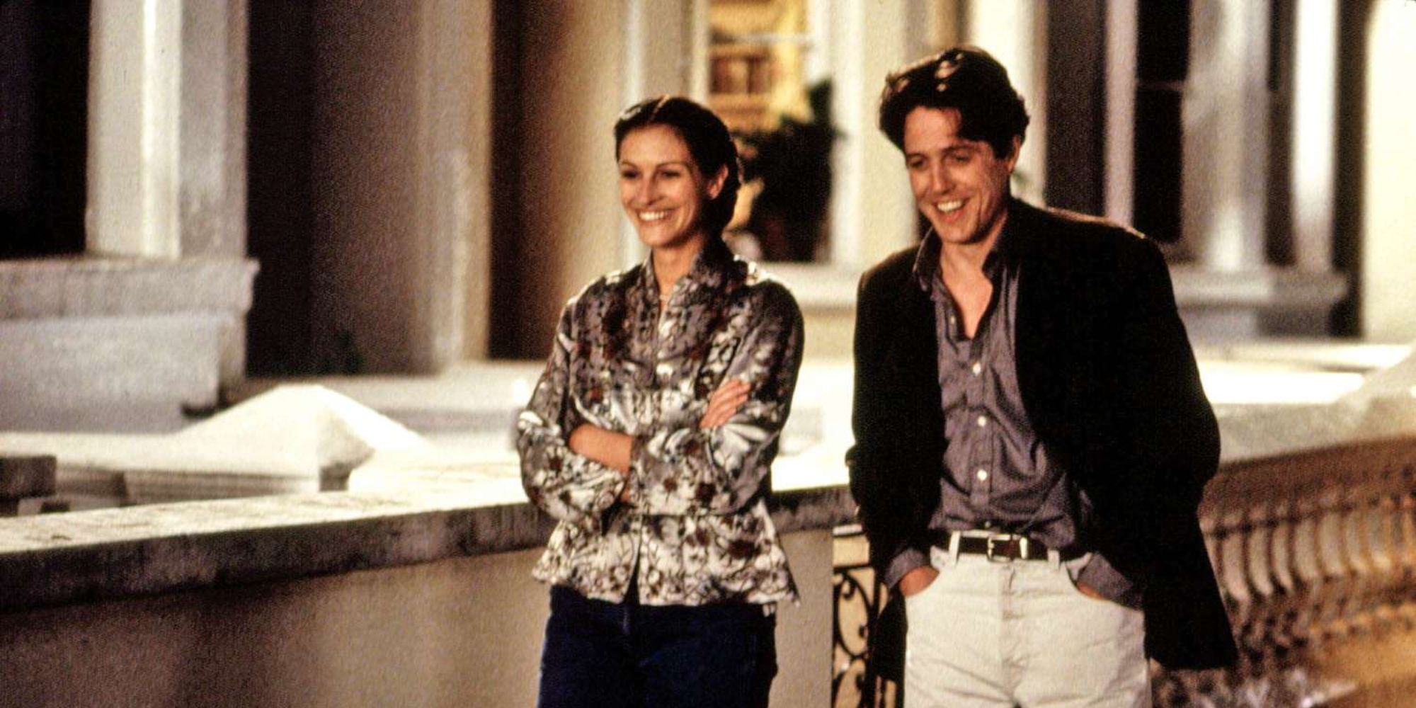 Julia Roberts and Hugh Grant walking down a street together in Notting Hill