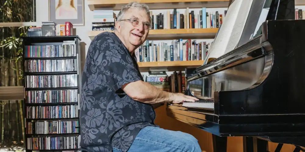 Randy Newman senta em seu piano
