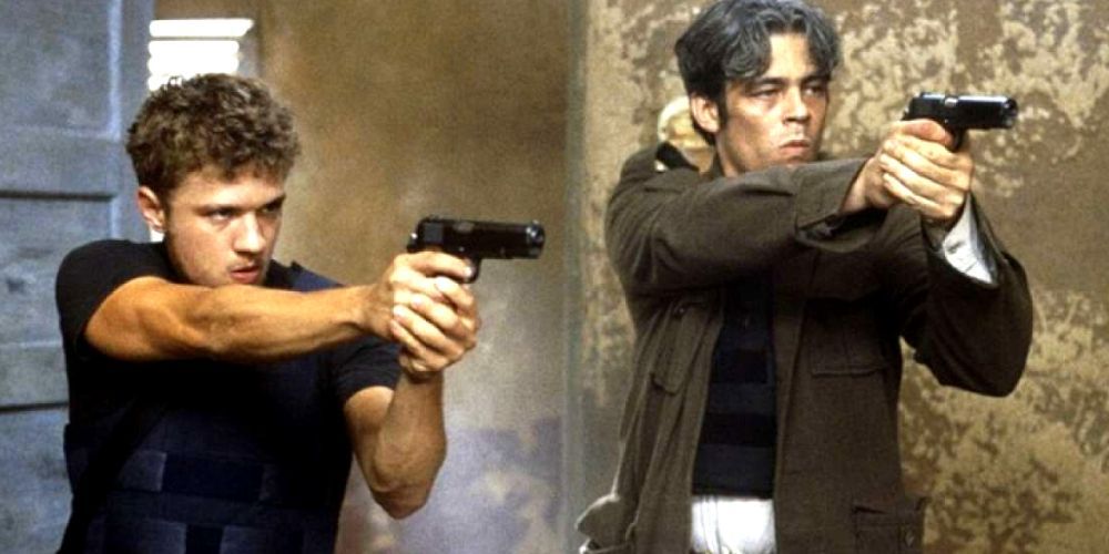 Ryan Phillippe e Benicio del Torro ficam lado a lado com armas em punho no Caminho da Arma