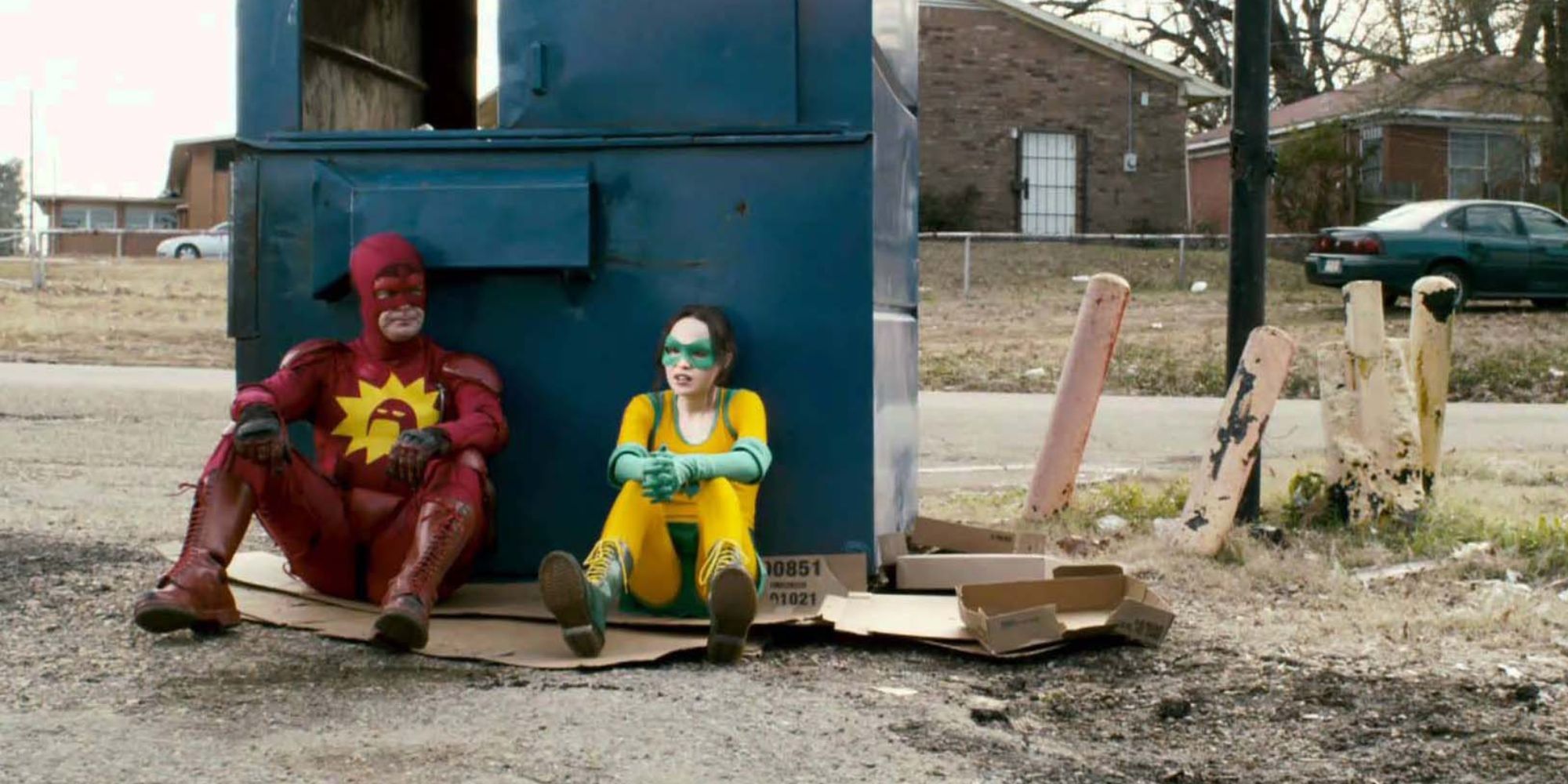 The Crimson Bolt and Boltie sitting by rubbish bin in empty suburban street