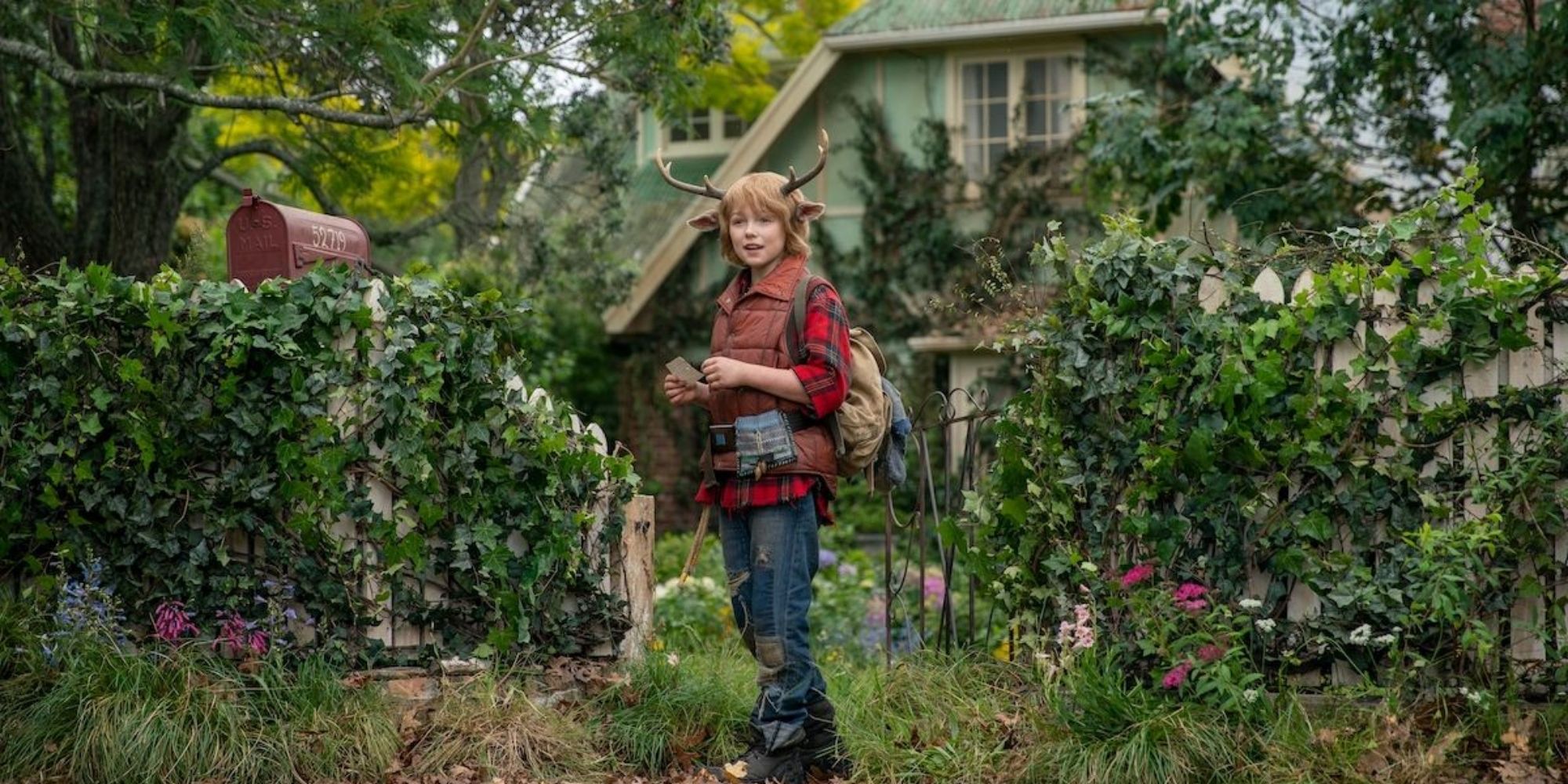 Gus standing in front of a ruined house in Netflix's Sweet Tooth.