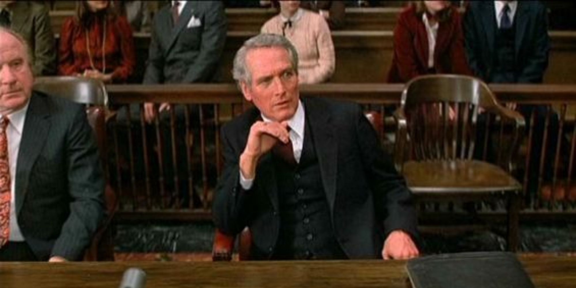 Frank Gavin sitting in a court room looking intently in The Verdict.