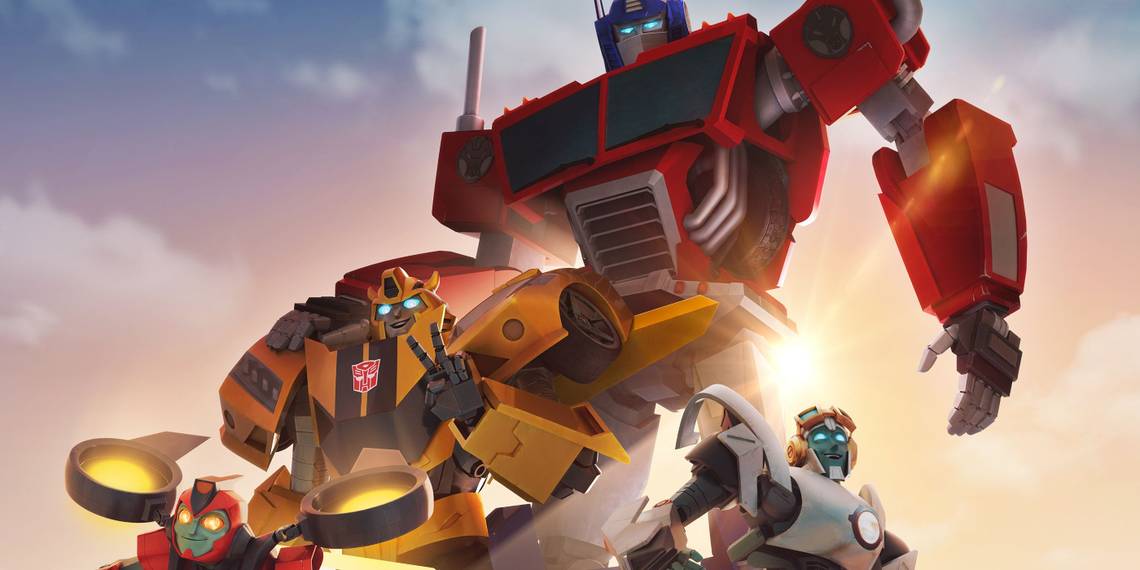 A screenshot of a 3D animated cartoon. It shows Optimus Prime, Bumblebee, Twitch, and Thrash with the sun rising behind them. Rays of sunlight stream past them and towards the camera. There is a lot of attention given to lighting and atmosphere.