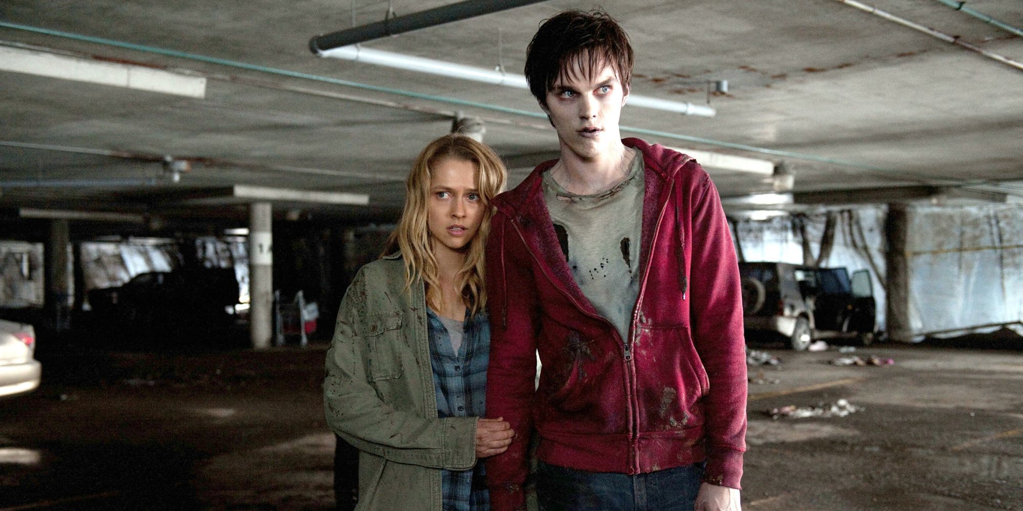 A young woman standing next to a protective zombie with a warm body.