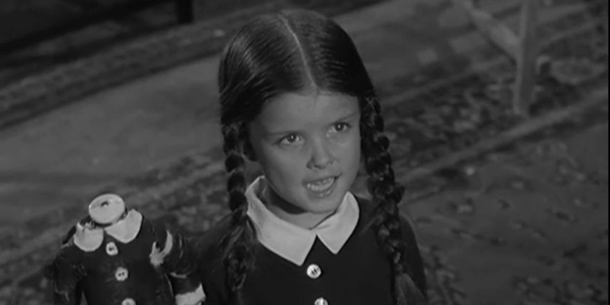 Lisa Loring como Wednesday Addams com uma boneca sem cabeça em A Família Addams de 1964