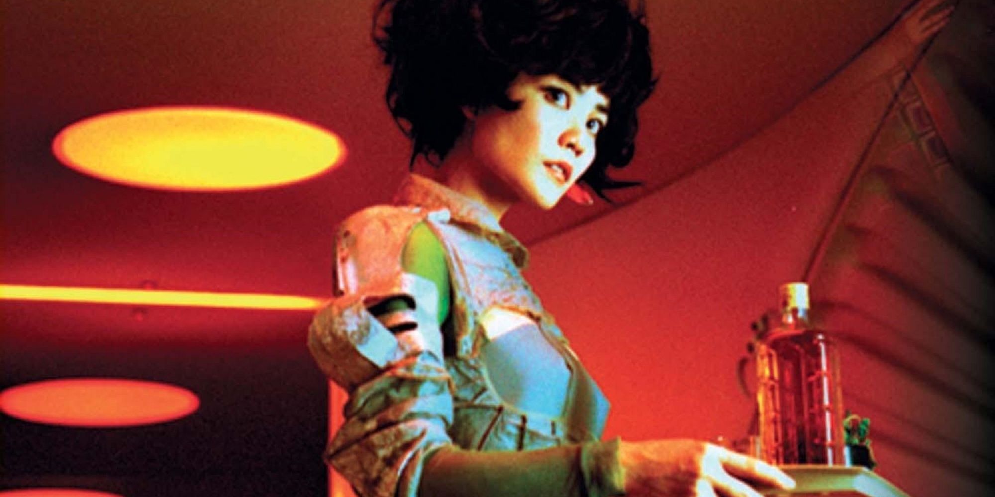 Gong Li's character holding a try of liquor in a neon red room in '2046.'