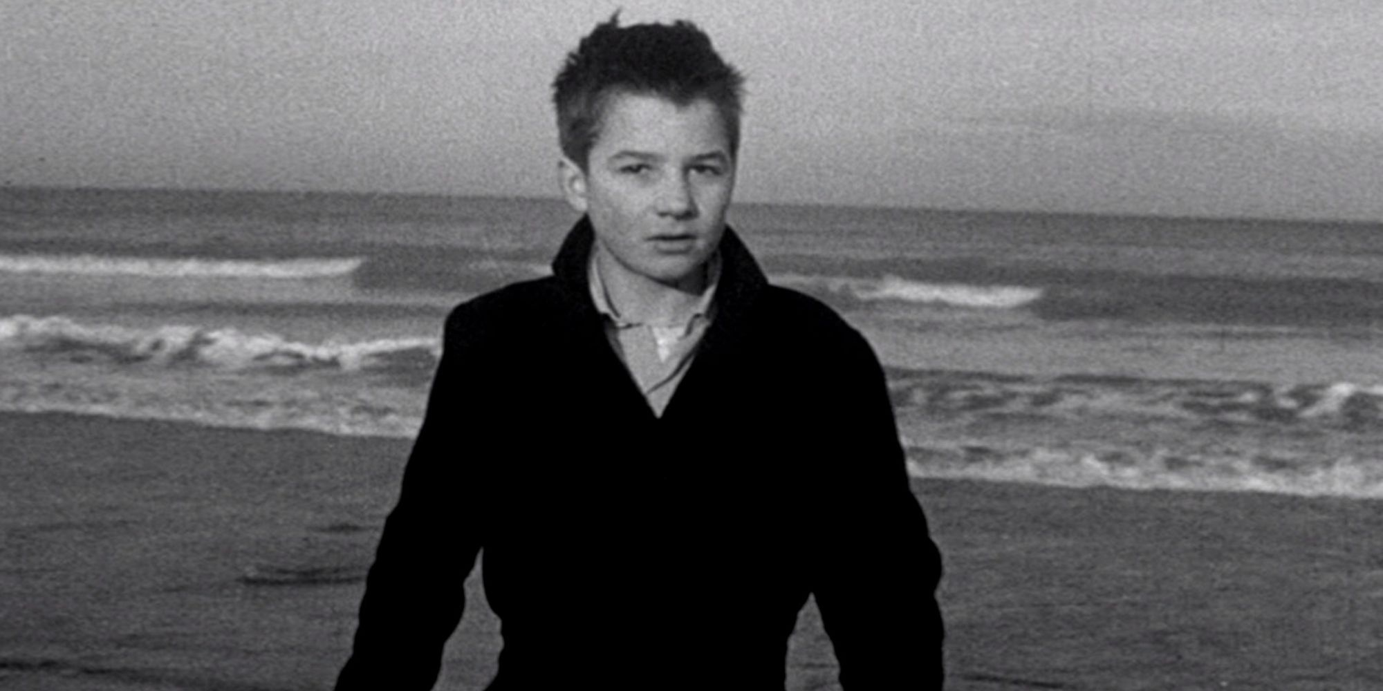 Jean-Pierre Léaud as Antoine Donel standing on a beach in The 400 Blows.