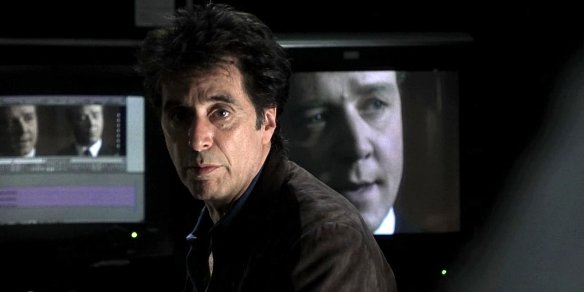 Lowell Bergman (Al Pacino) staring offscreen with Dr. Jeffrey Wigand (Russell Crowe) appearing on a television behind him in 'The Insider'