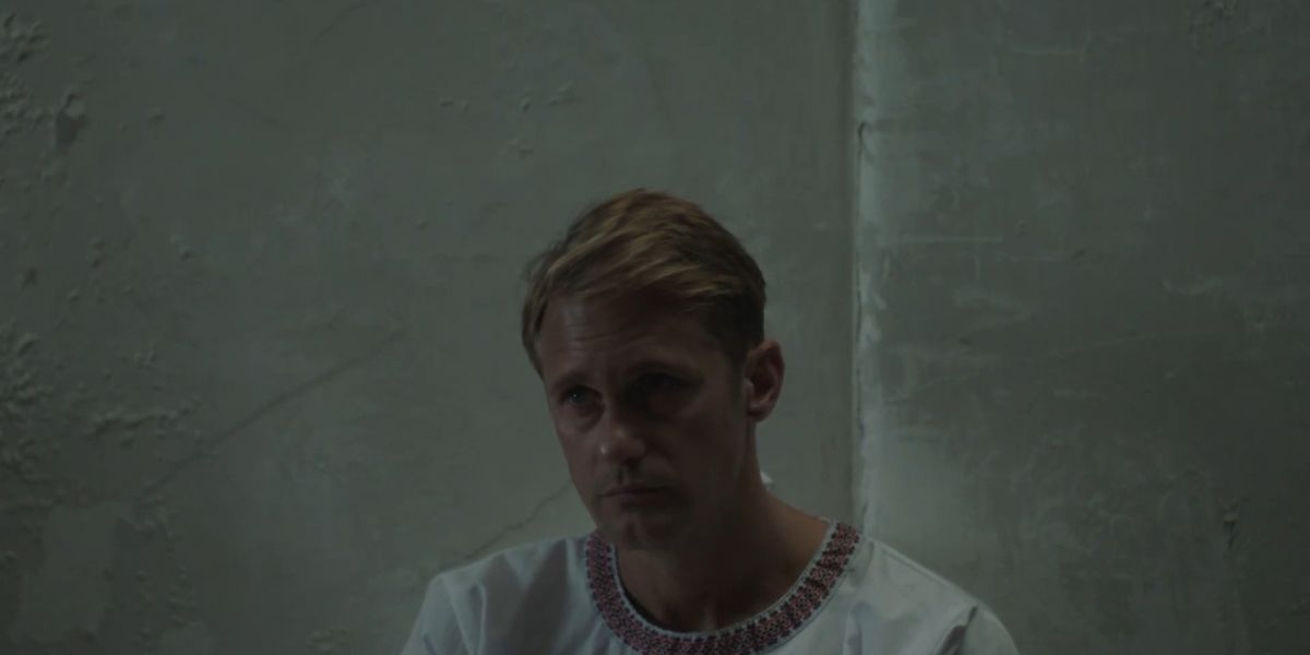 Alexander Skarsgard as James looking bored in a white room in the film Infinity Pool