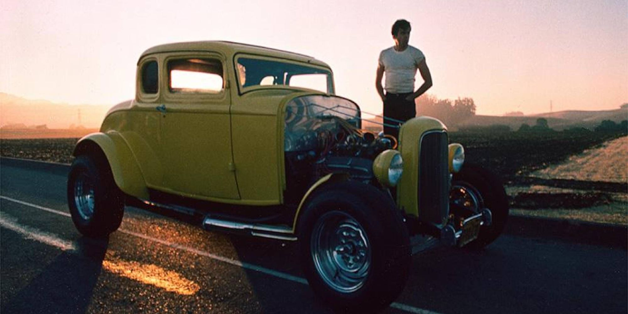 Harrison Ford as Bob standing by a car in American Graffiti