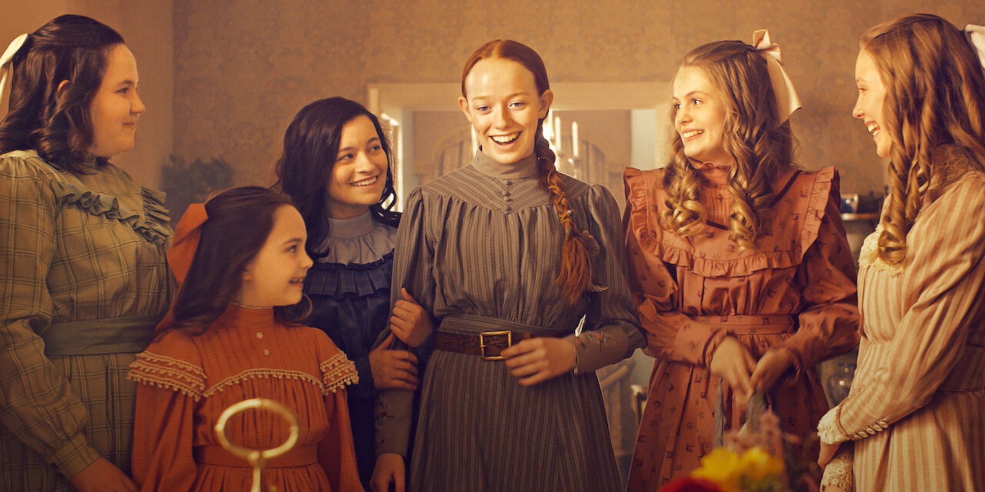 Cast ensemble of 'Anne with an E' standing around a table