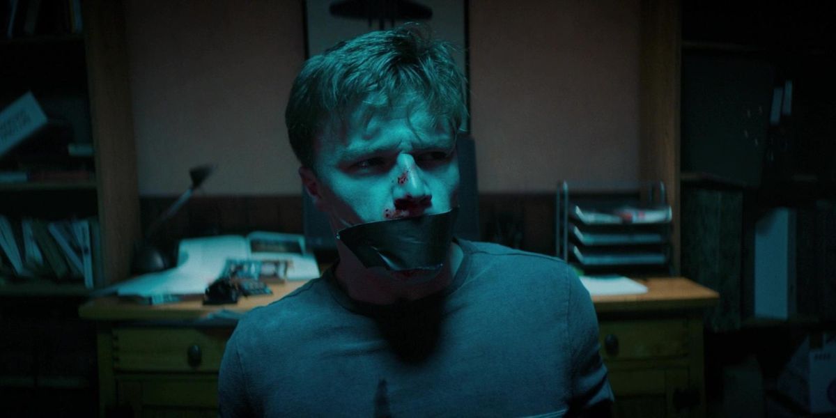 A man with tape over his mouth in Await Further Instructions