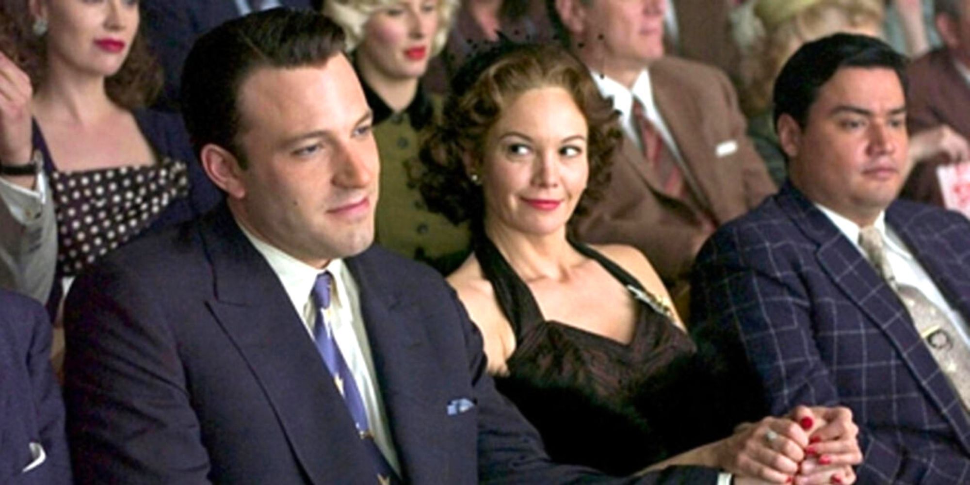 Ben Affleck sitting next to Diane Lane in a crowd of people holding hands in Hollywoodland