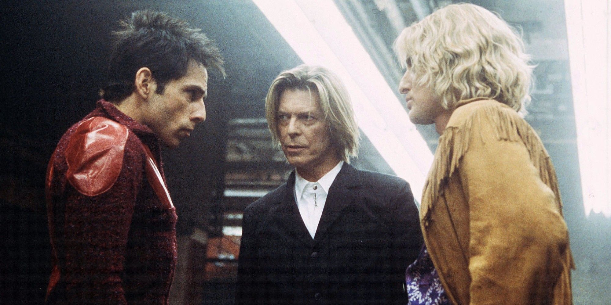 David Bowie and two male models discuss the terms of the fashion show competition. 