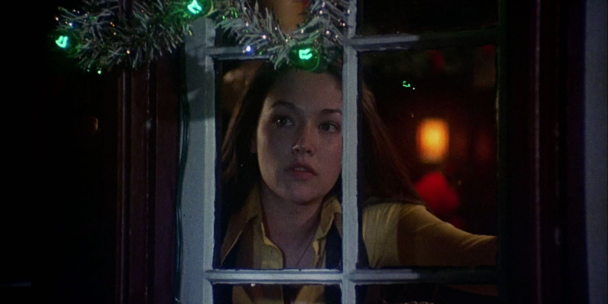 Olivia Hussey looks cautiously out her window in Black Christmas