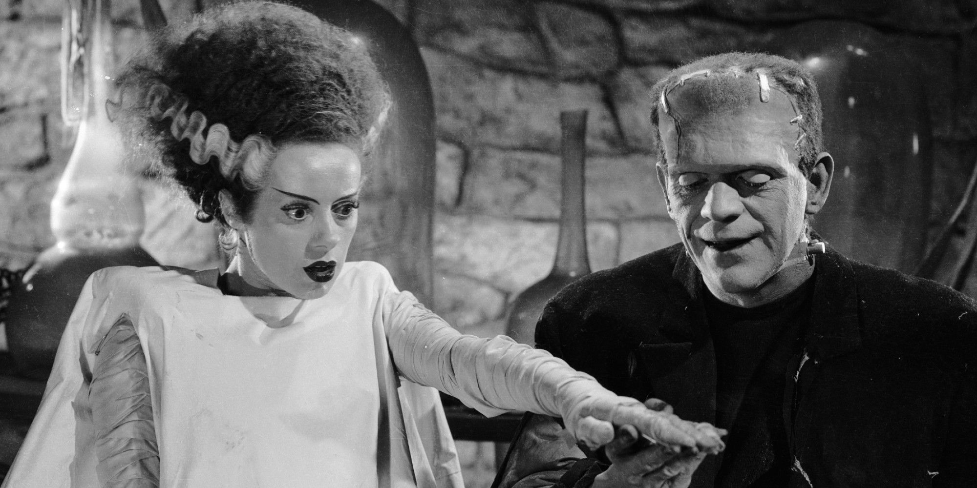 The Monster smiling while his Bride points at something off-camera in 'The Bride of Frankenstein'