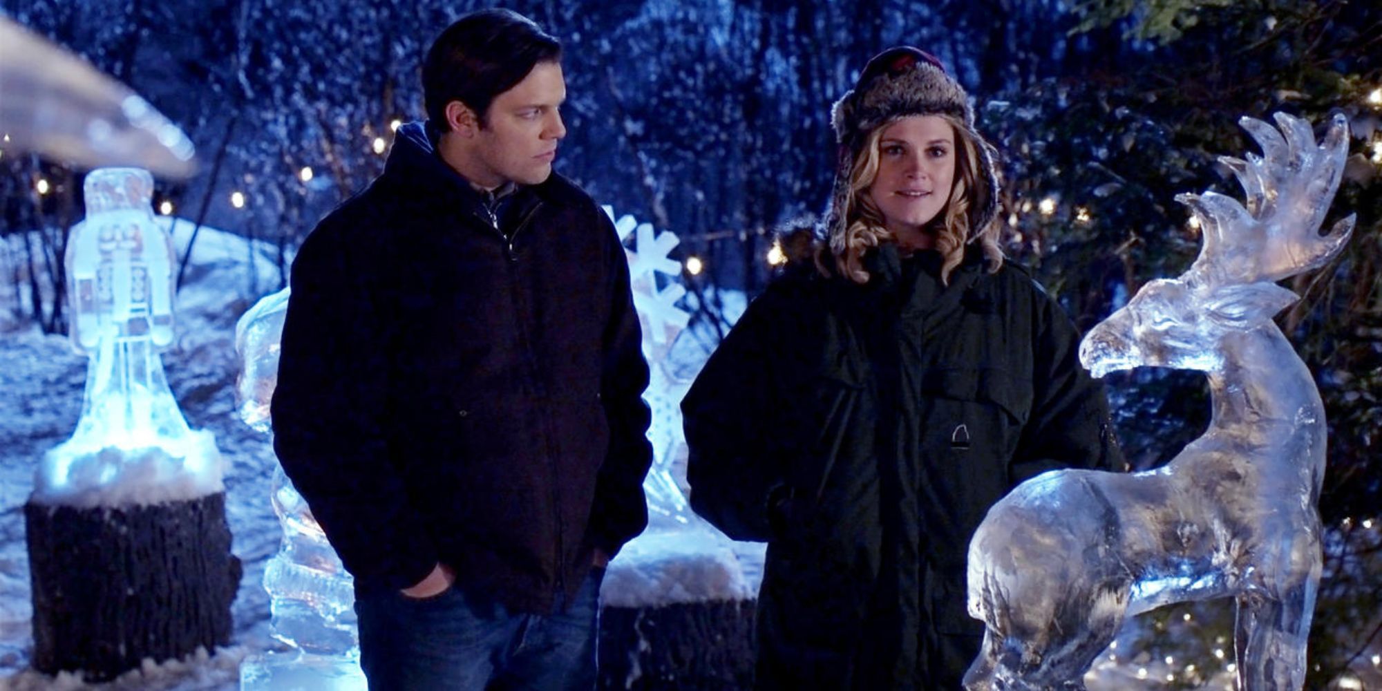 Jake e Ellen da herança de Natal juntos perto da estátua de neve