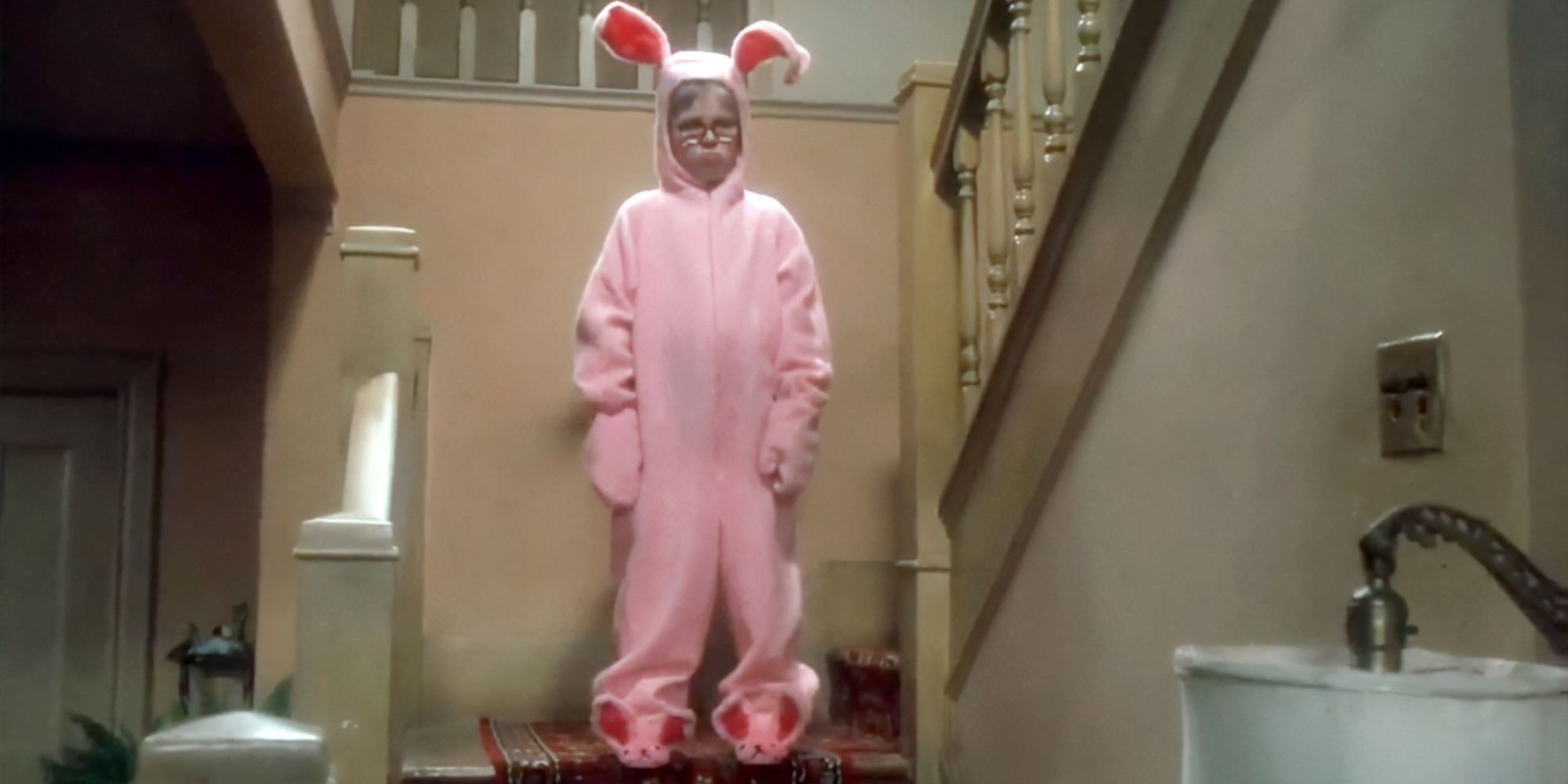 Ralph estava na escada, parecendo taciturno em um traje de coelho rosa