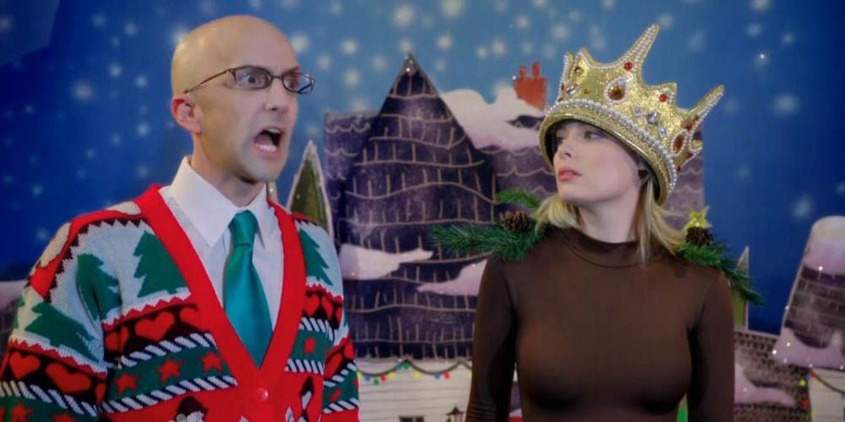 Gillian Jacobs  Britta wearing a crown next to Jim Rash's Dean Pelton wearing a christmas sweater in the Regional Holiday Music episode of Community