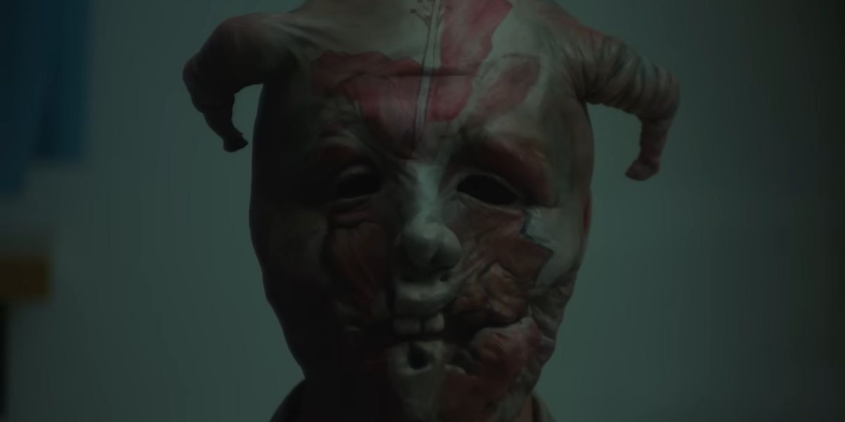 Un personnage portant un masque de démon dans Infinity Pool.