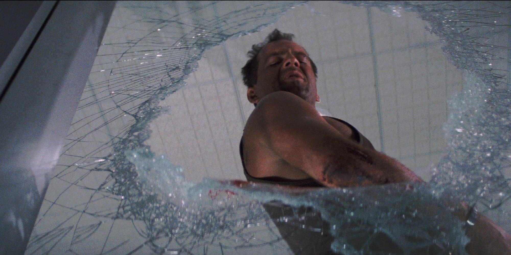 Bruce Willis stares at a broken window in Die Hard