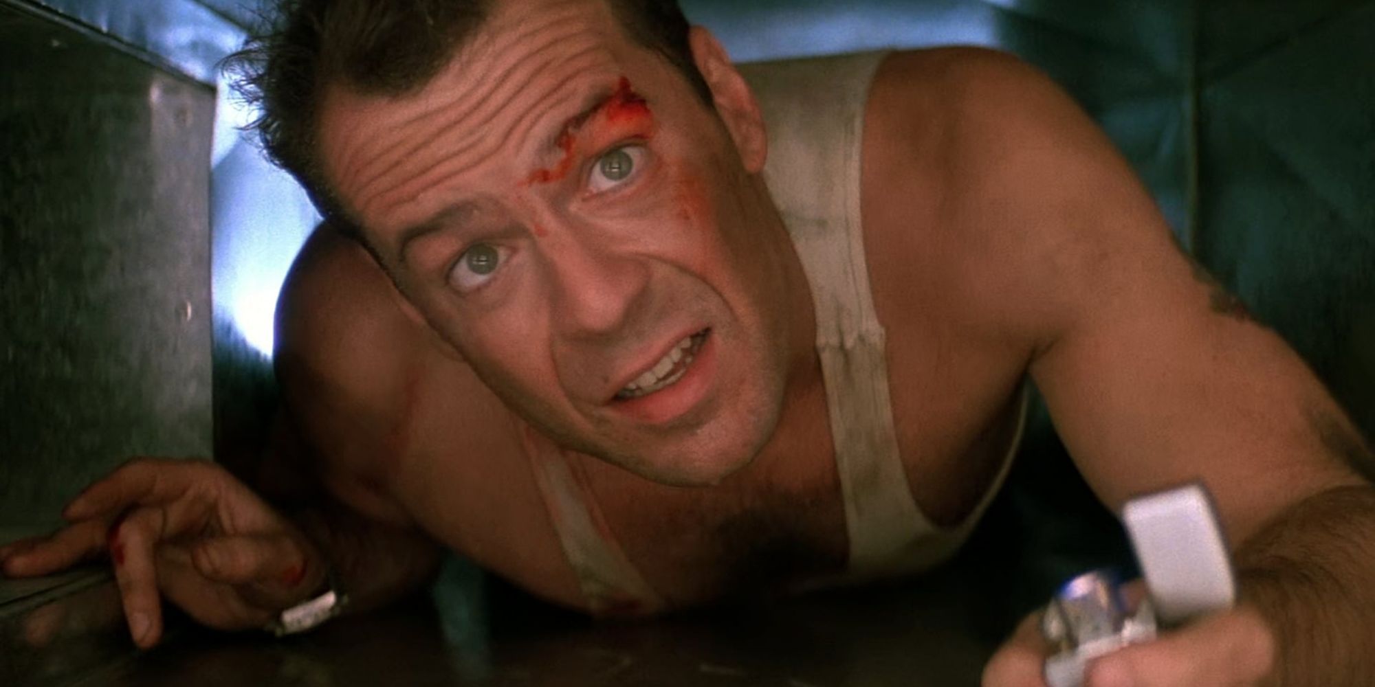 Bruce Willis as John McClane crawls through a vent with lighter in hand in Die Hard