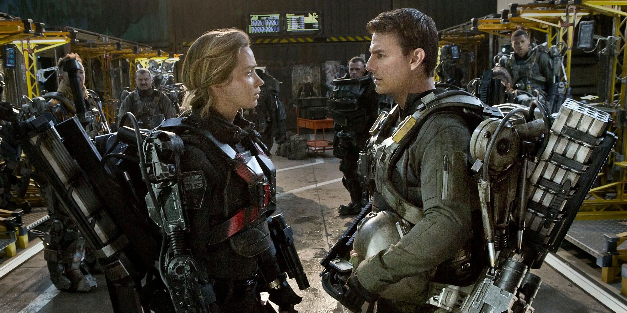 Rita Vrataski (Emily Blunt) and William Cage (Tom Cruise) facing each other in their mech-suits in Edge of Tomorrow