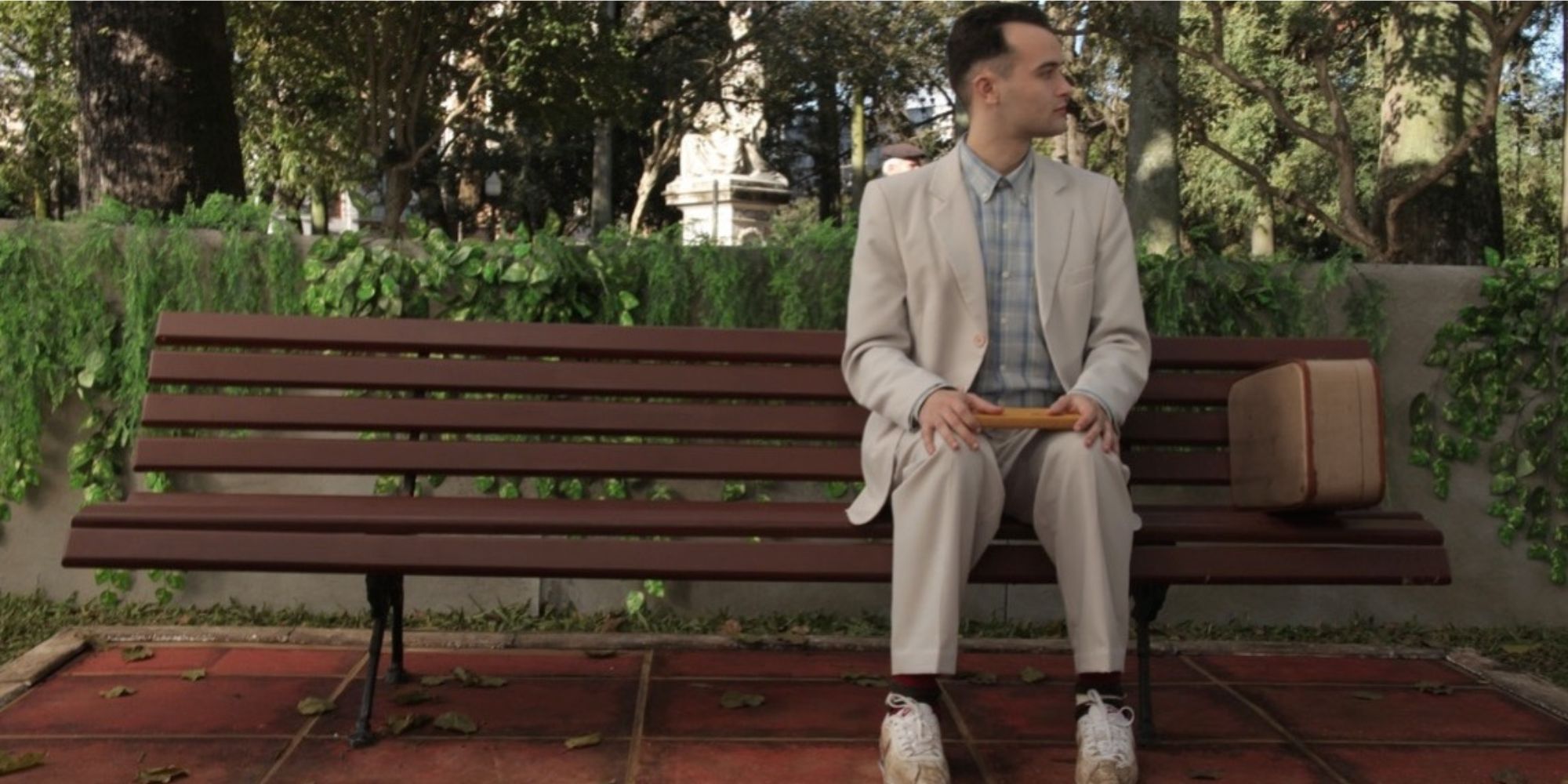 Forrest Gump sitting on a bench and turning to his left.
