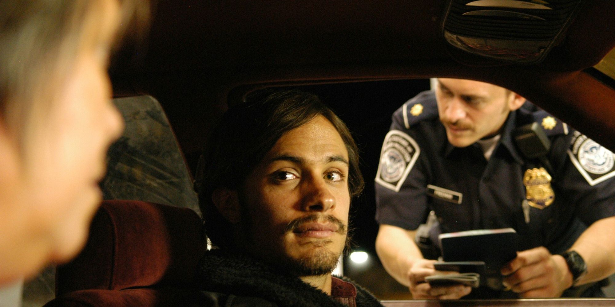 man in his car being interrogated by a cop