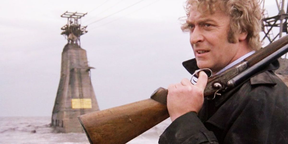 Michael Caine as Jack Carter holding a gun over his shoulder in Get Carter