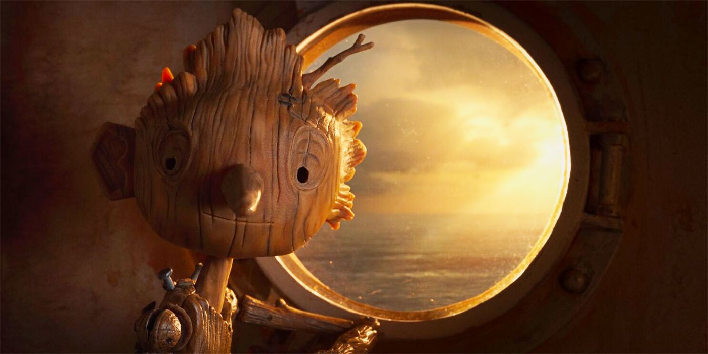 Pinocchio looking at the camera standign beside a round window in Guillermo del Toro's Pinocchio