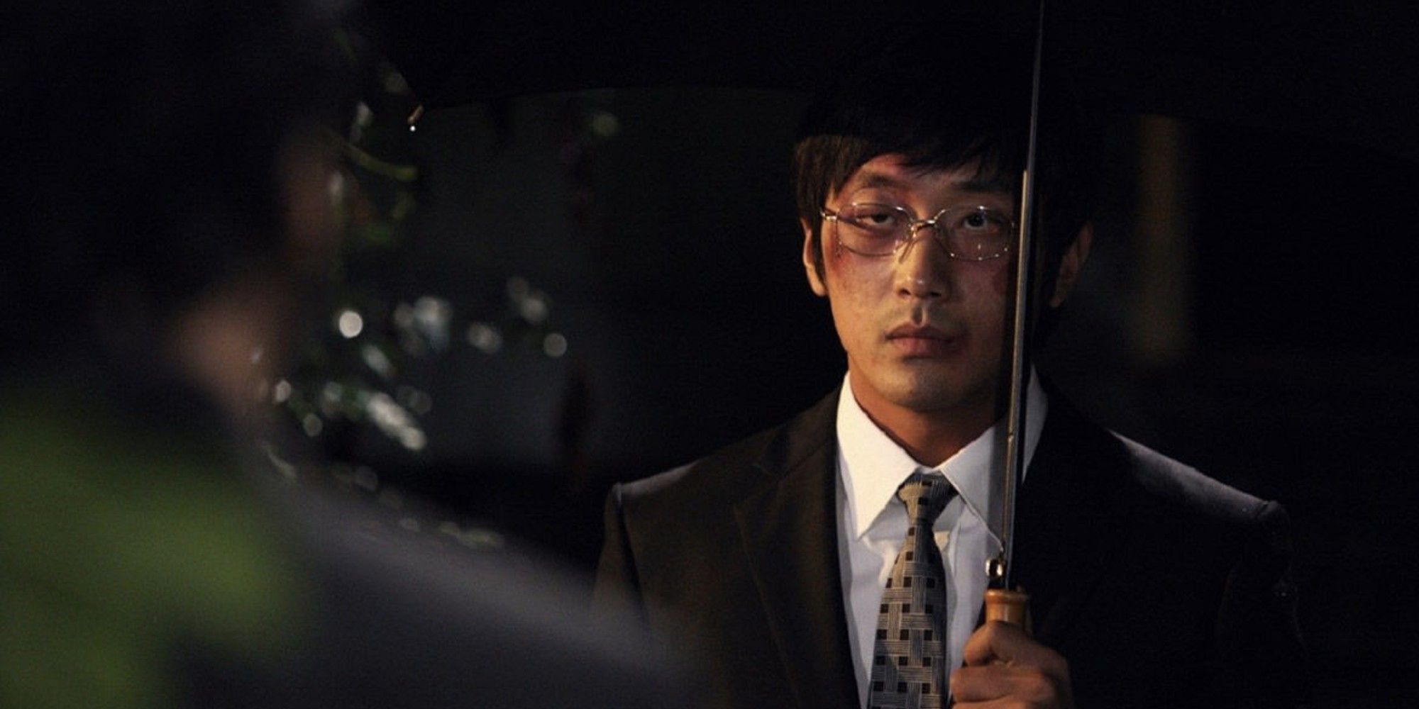 Ha Jung-woo holding an umbrella in 'The Chaser'