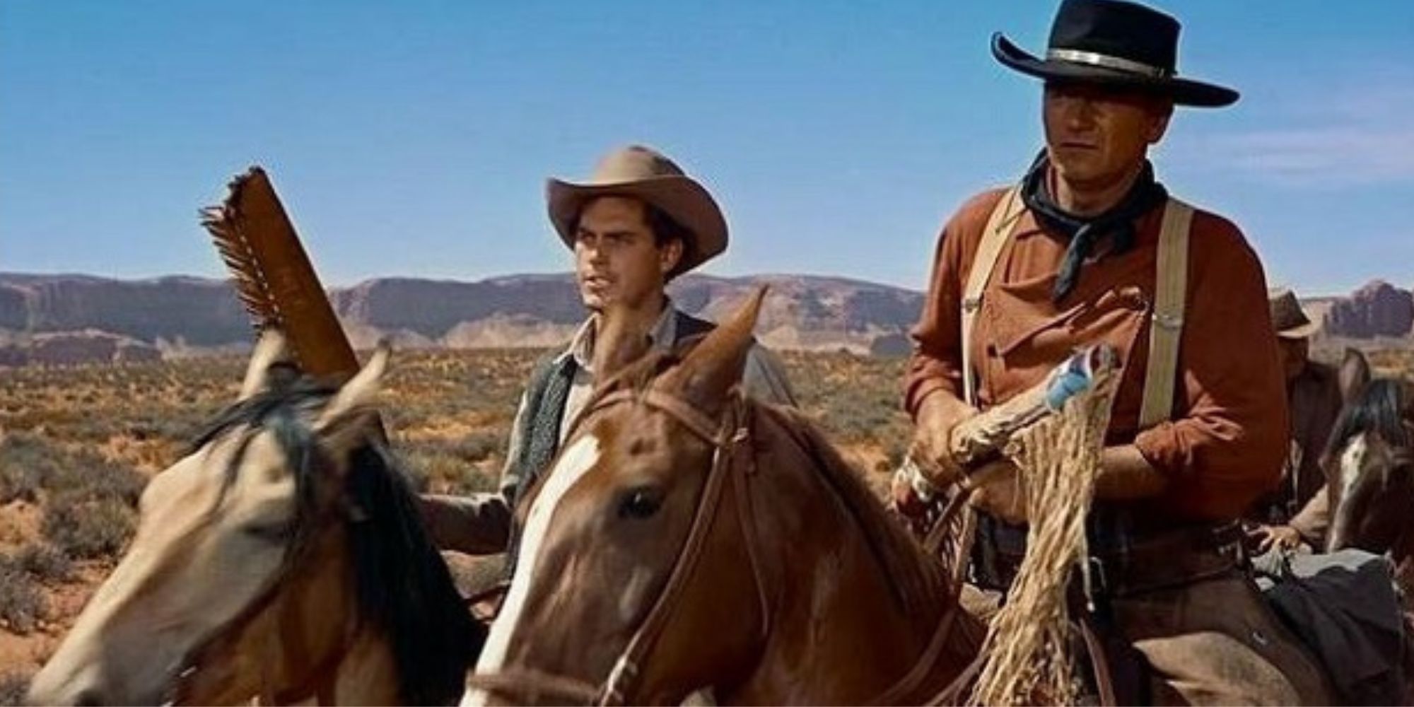 Jeffrey Hunter and John Wayne in the desert on horses in The Searchers
