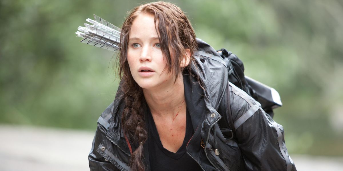 Jennifer Lawrence dans le rôle de Katniss se mettant à l'abri dans les bois dans The Hunger Games