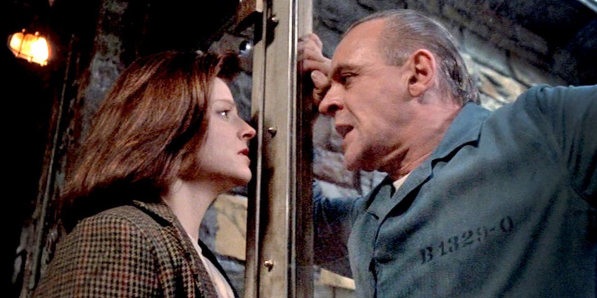 Jodi Foster looking at Anthony Hopkins behind the glass of his cell in The Silence of the Lambs