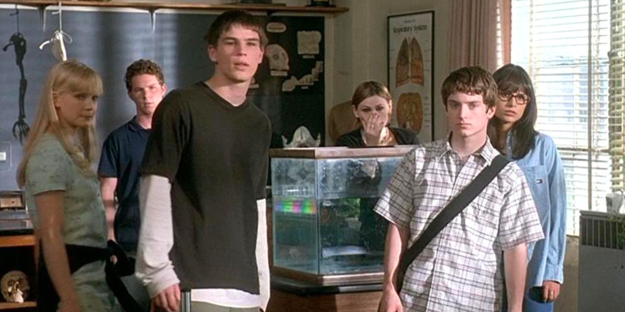 Josh Hartnett and Elijah Wood standing next to each other and others standing behind them in The Faculty