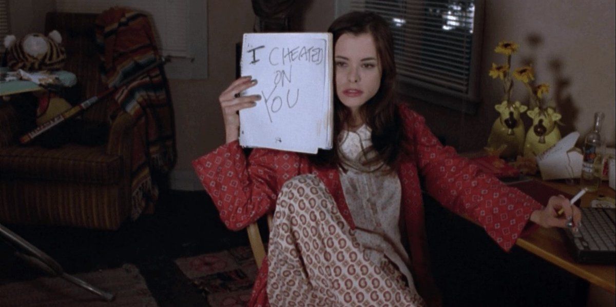 Parker Posey as Miami holding up a sign that says I cheated on you in Kicking and Screaming (1995)