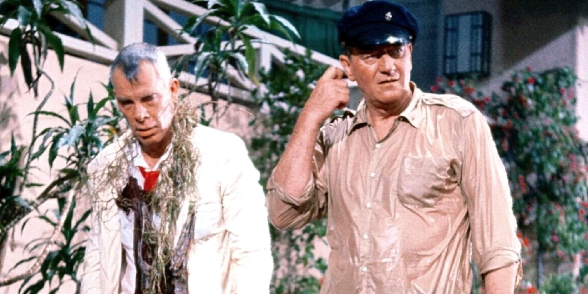 Lee Marvin next to John Wayne both soaking wet standing in a fish pond in Donovan's Reef