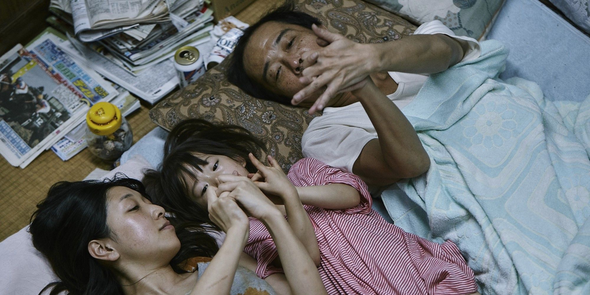 Lily Franky, Sakura Andô, and Miyu Sasaki lying on the floor in 'Shoplifters'