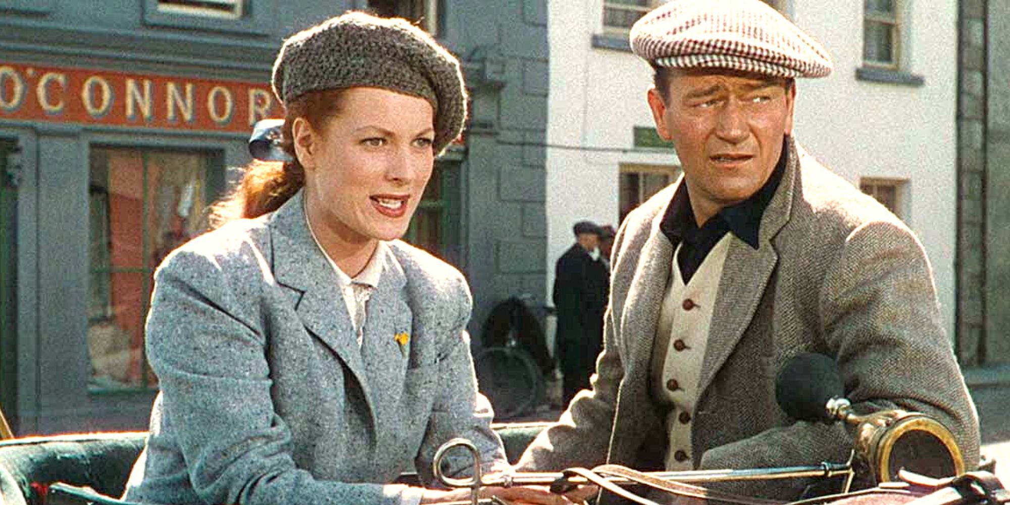 Maureen O'Hara and John Wayne sitting in a carriage looking forward in The Quiet Man-1