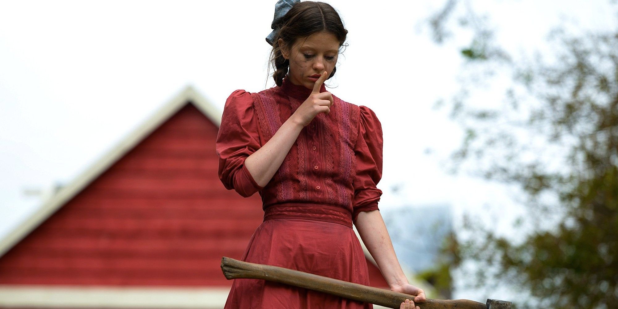 Mia Goth doing the quiet sign while looking down at someone in Pearl.