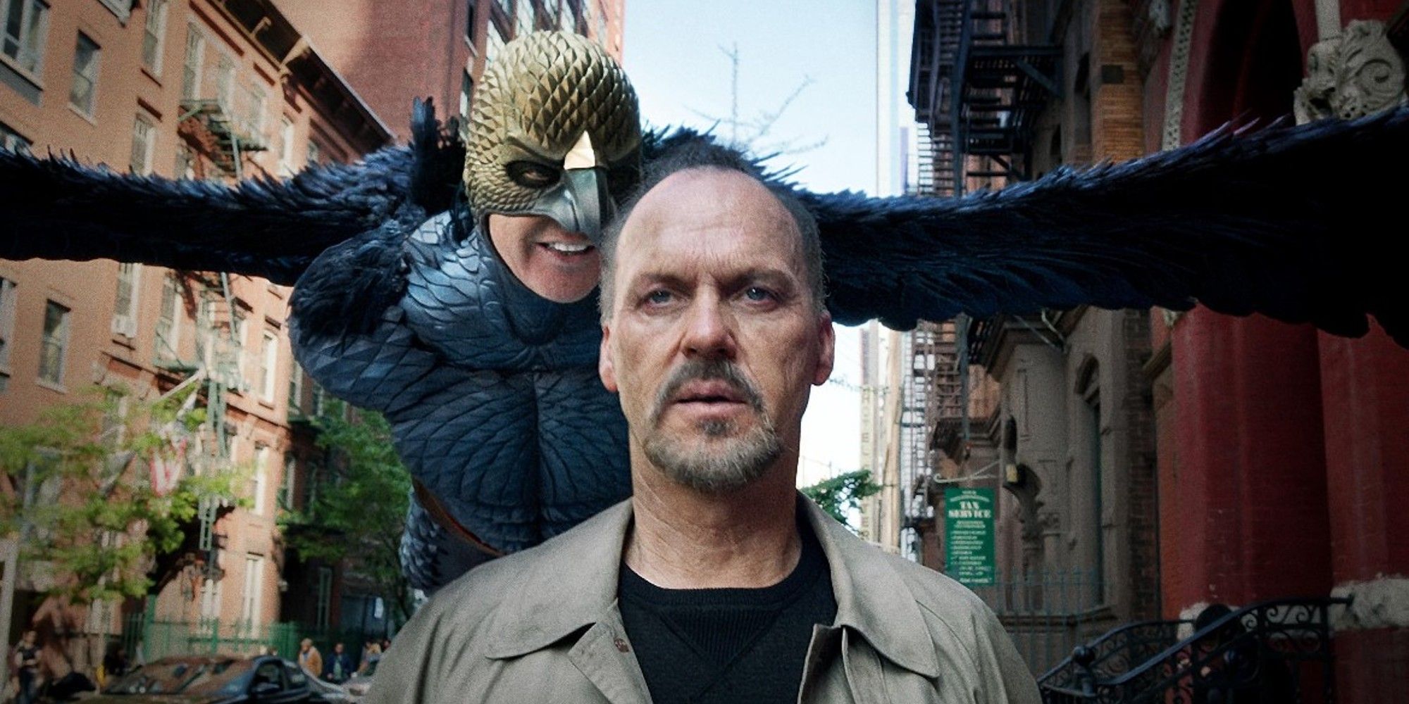 Riggan Thompson walking down the street with his superhero alterego flying behind him in Birdman