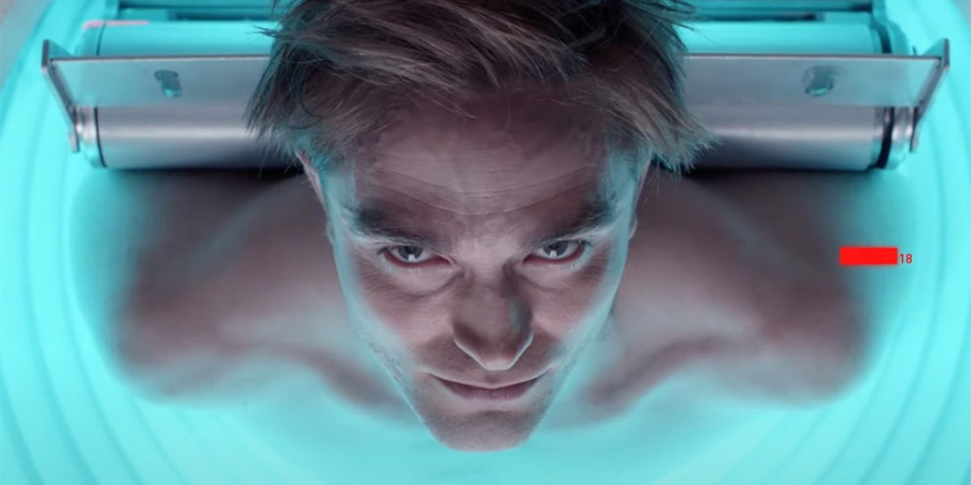 Robert Pattinson in a cryo chamber making eye contact with the camera in Mickey 17