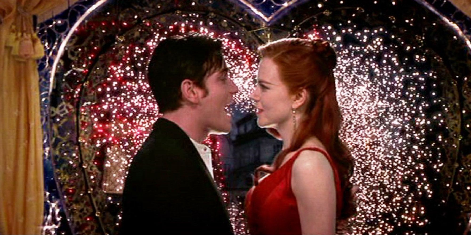 Christian and Satine sing while lights shine in the background of the Moulin Rouge!